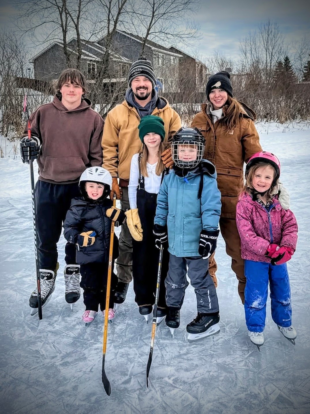 Owner of Ringers Outdoor Property Services with his wife and five children on a frozen lake