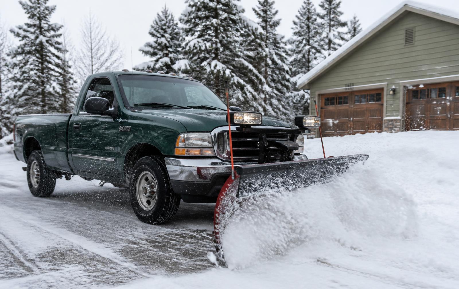 Truck plowing a snowy driveway